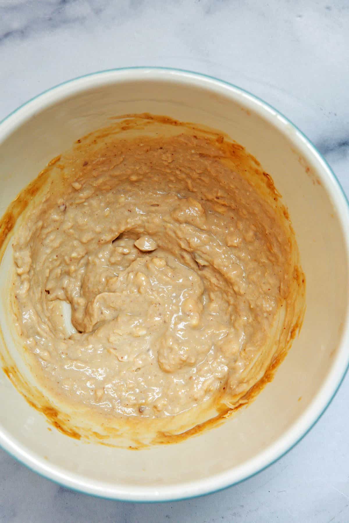 Caesar dressing ingredients being mixed together in bowl.