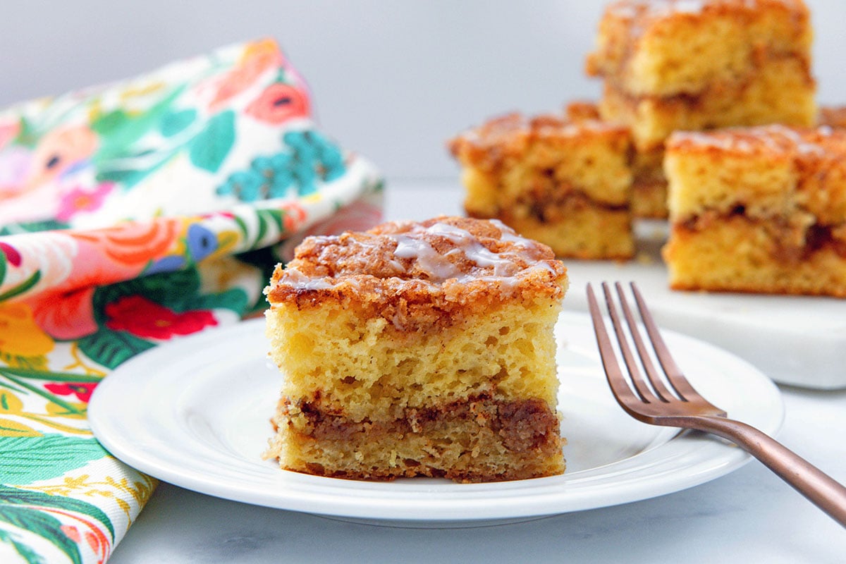 Landscape head-on view of piece of cake mix coffee cake with more pieces in background.