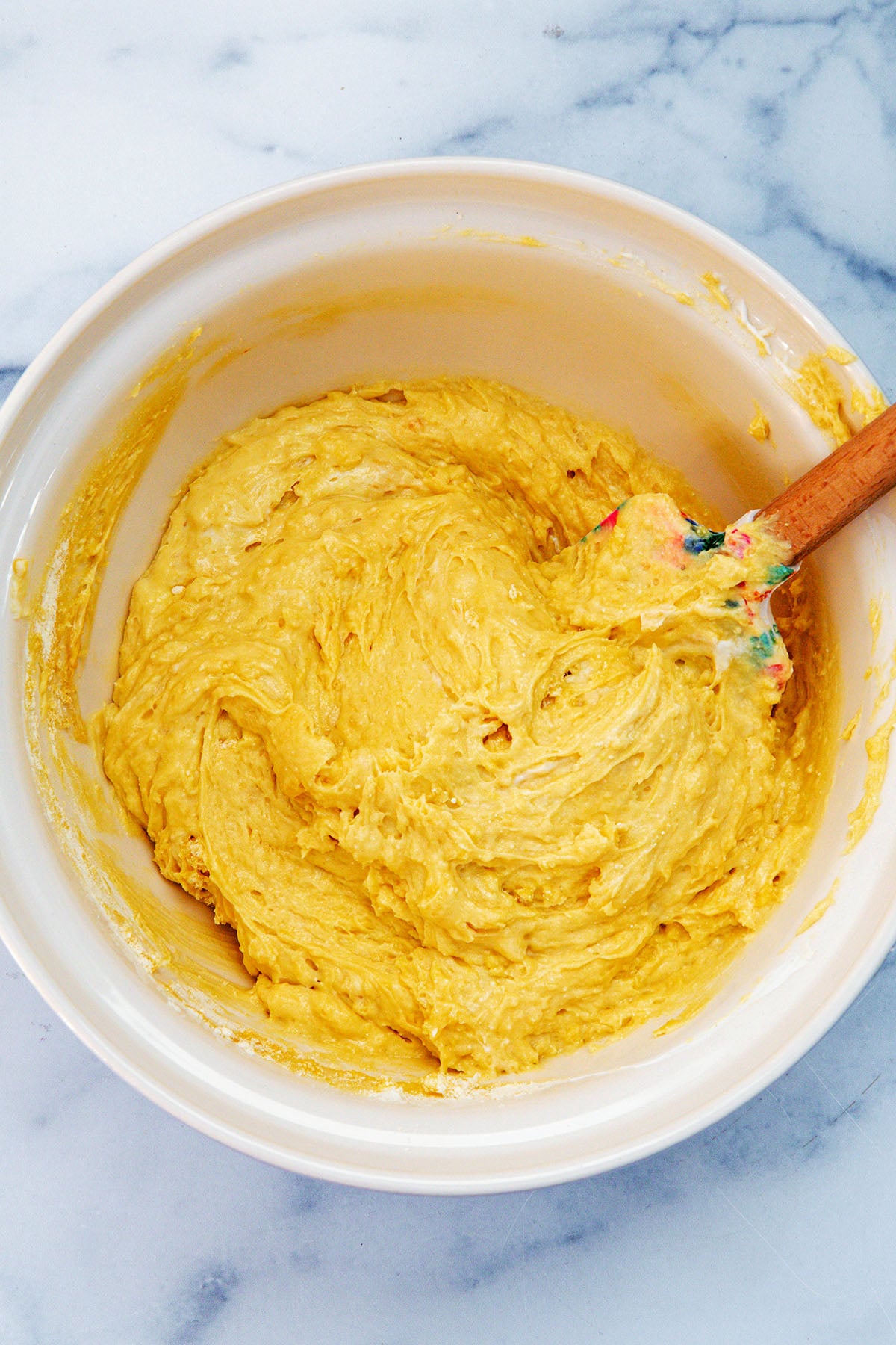 Cake mix coffee cake batter in mixing bowl with spatula.