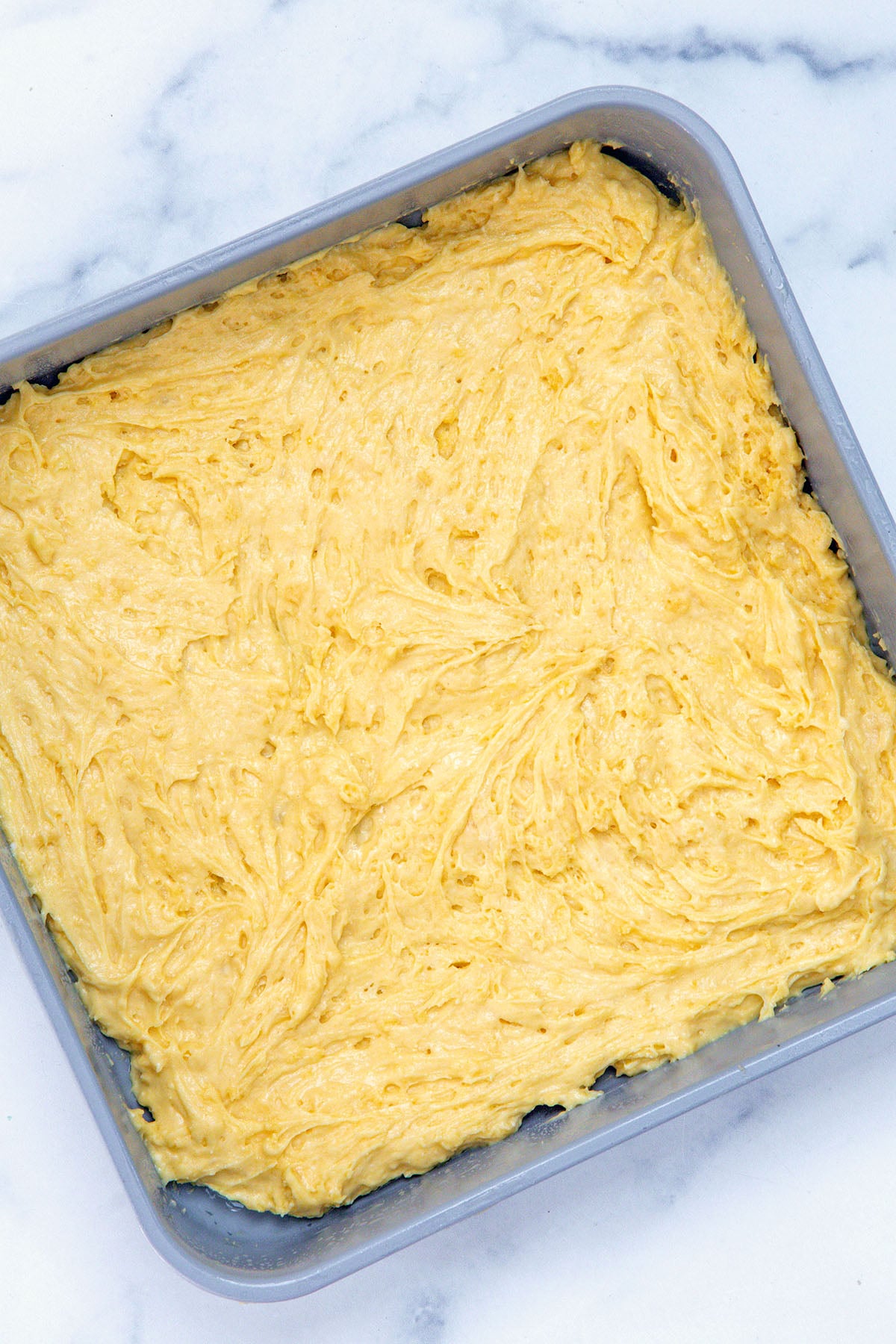 Layer of coffee cake batter in square pan.