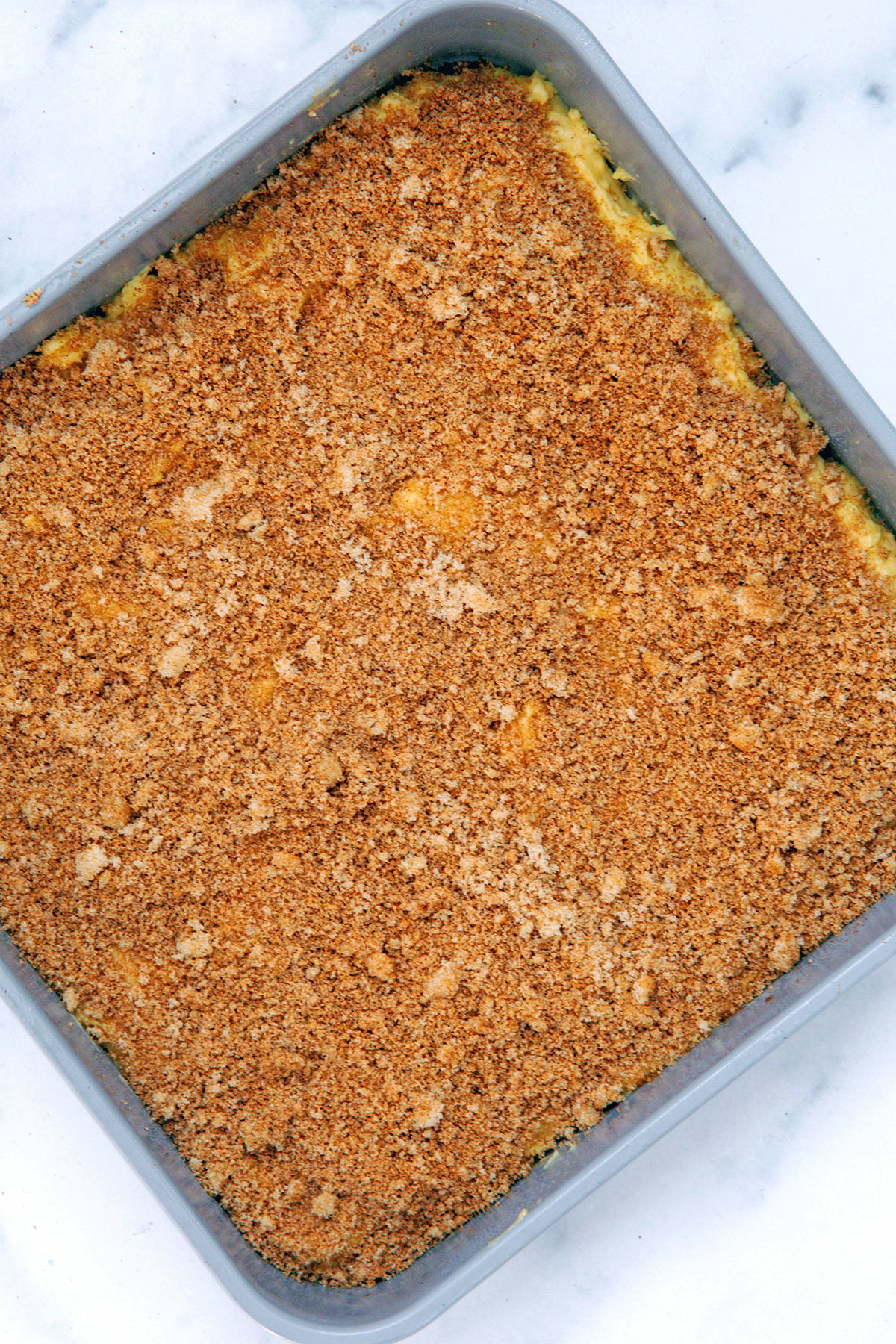 Layer of coffee cake batter with cinnamon brown sugar mixture over the top.