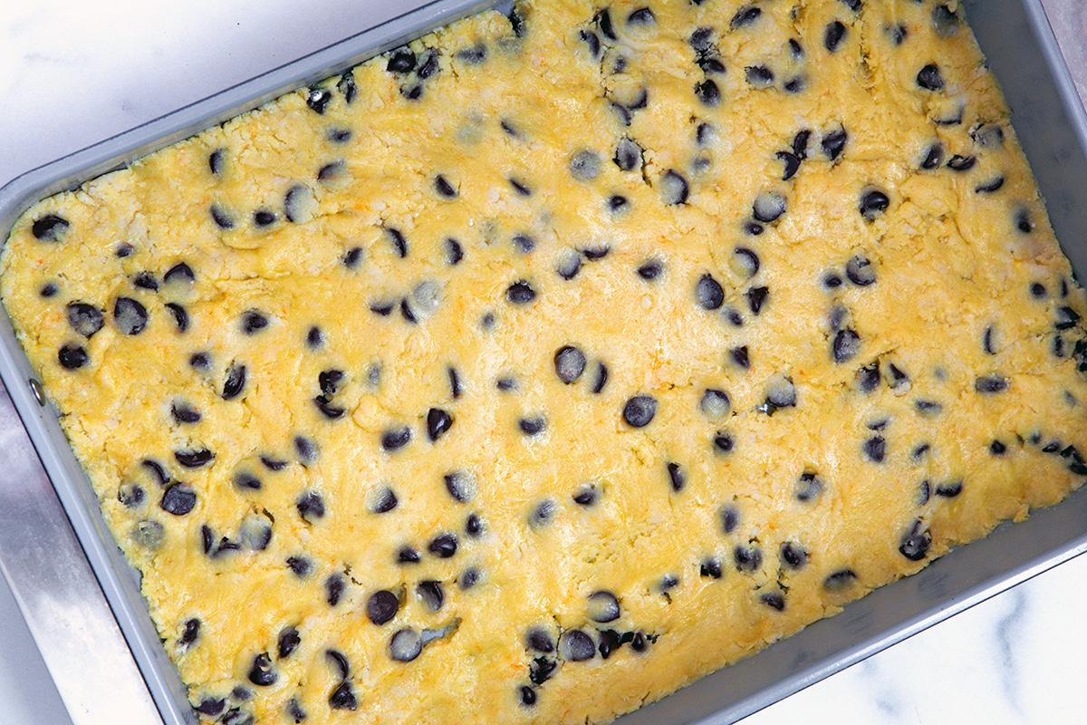 Chocolate chip cookie dough pressed into cake pan.