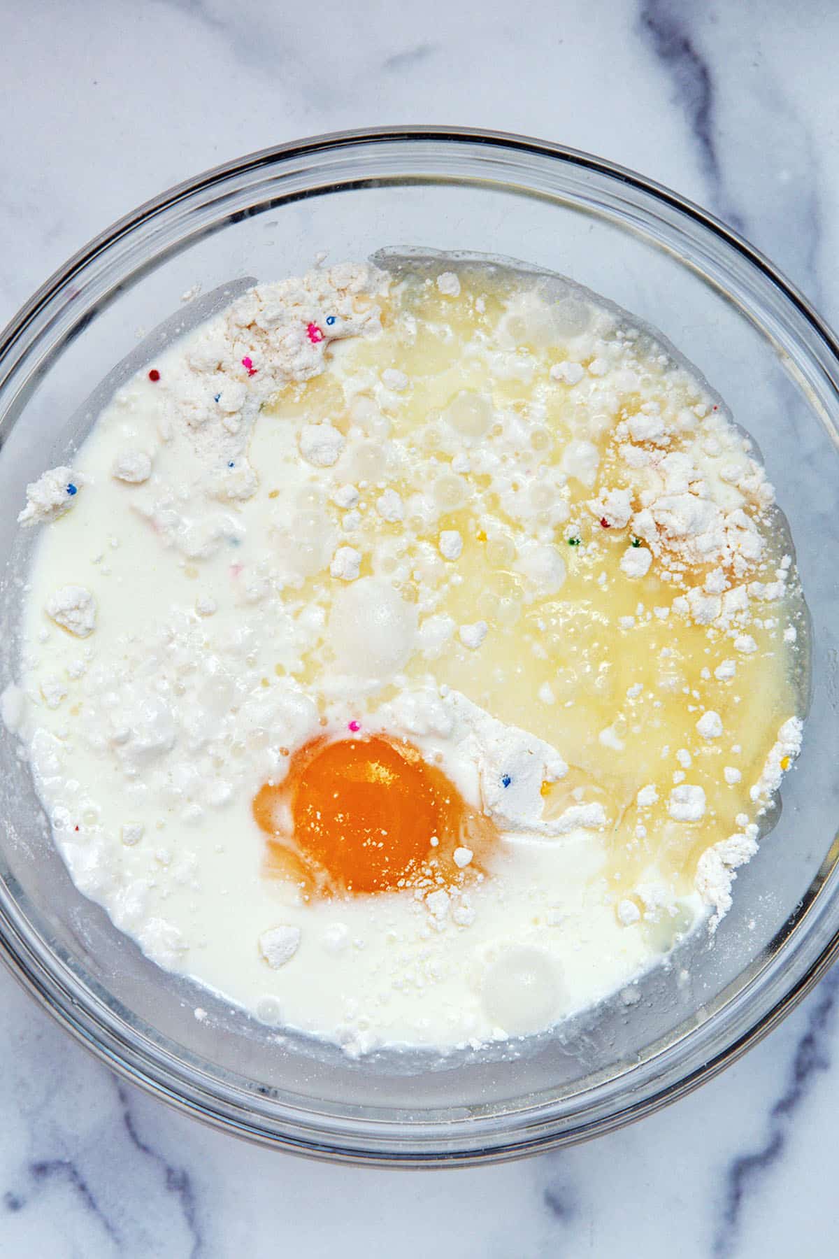 Cake mix, egg, and milk in mixing bowl.