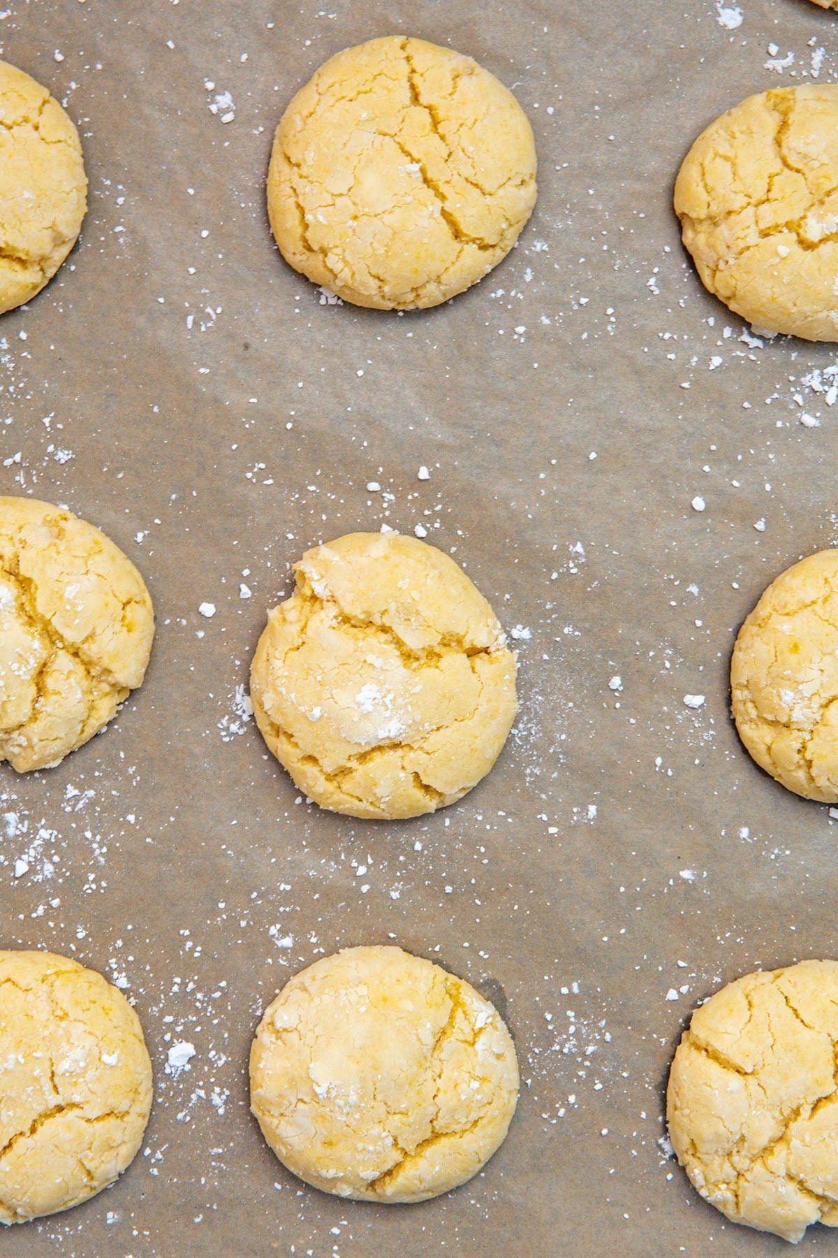 Lemon cake mix cookies baked on parchment paper-lined baking sheet.