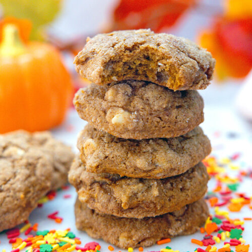 Closeup view of a stack of pumpkin cookies with cake mix with sprinkles all around.