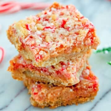 Closeup view of candy cane crumble bars stacked on each other.