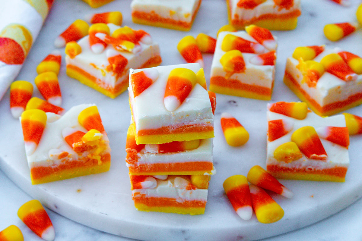 Landscape overhead view of candy corn fudge and candy corn candies on a marble platter.