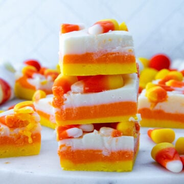 Closeup view of a stack of candy corn fudge with actual candy corns on top.