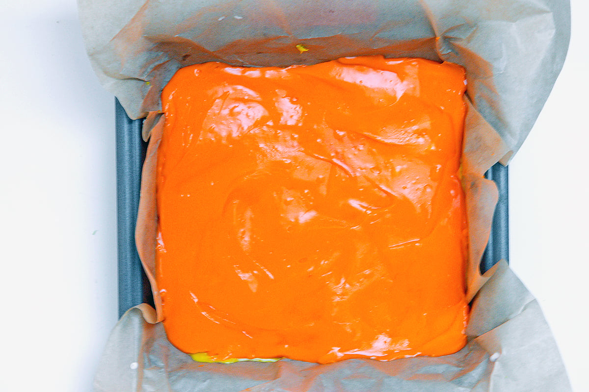 Landscape overhead view of orange chocolate in square pan.