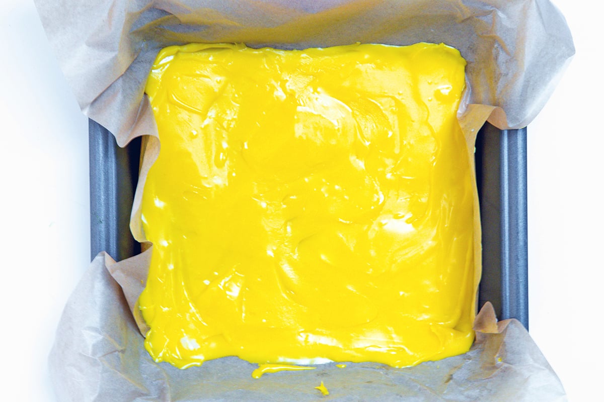 Landscape overhead view of yellow chocolate in square pan.