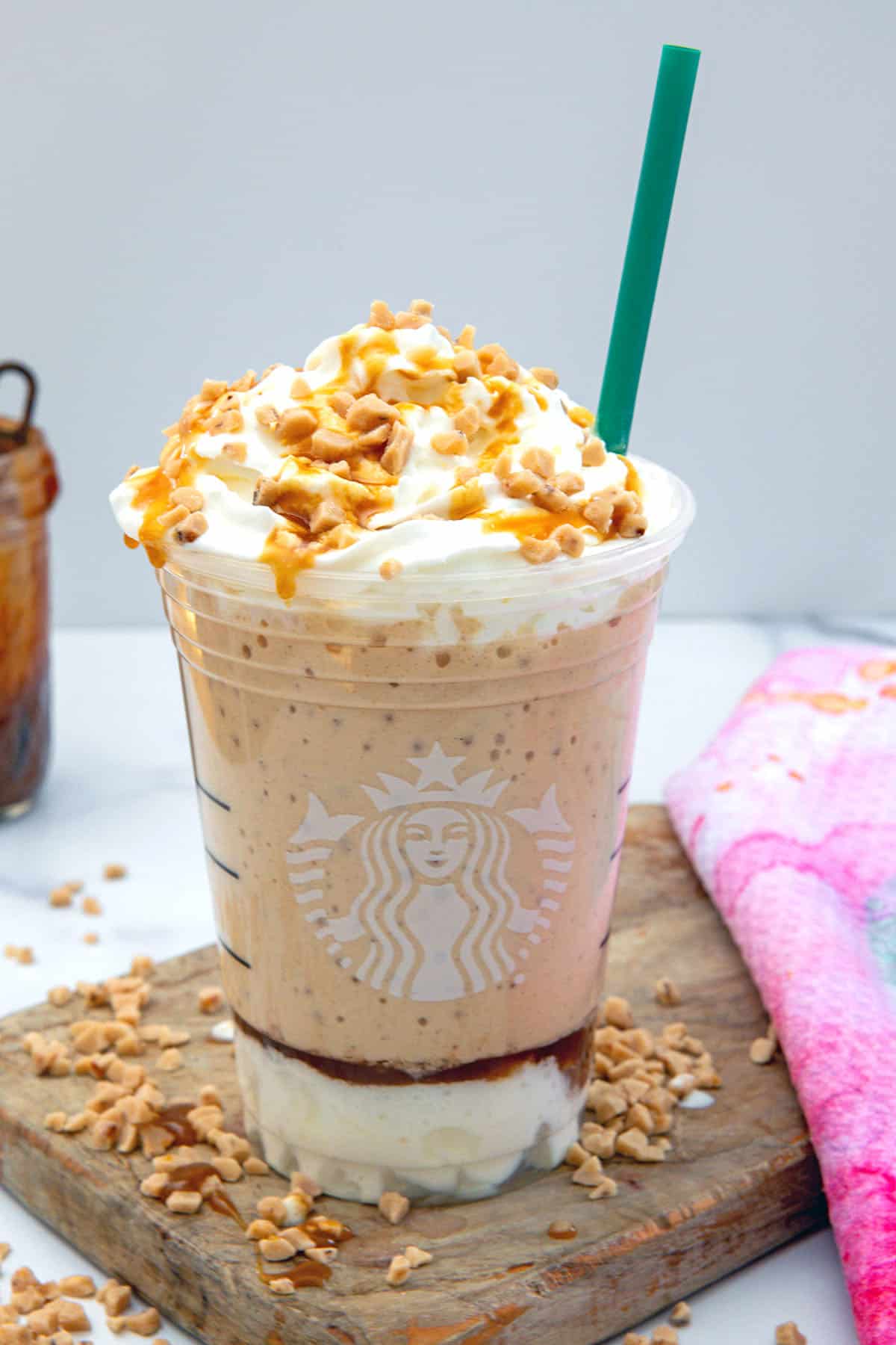 Overhead view of Caramel Ribbon Crunch Frappuccino with green straw.