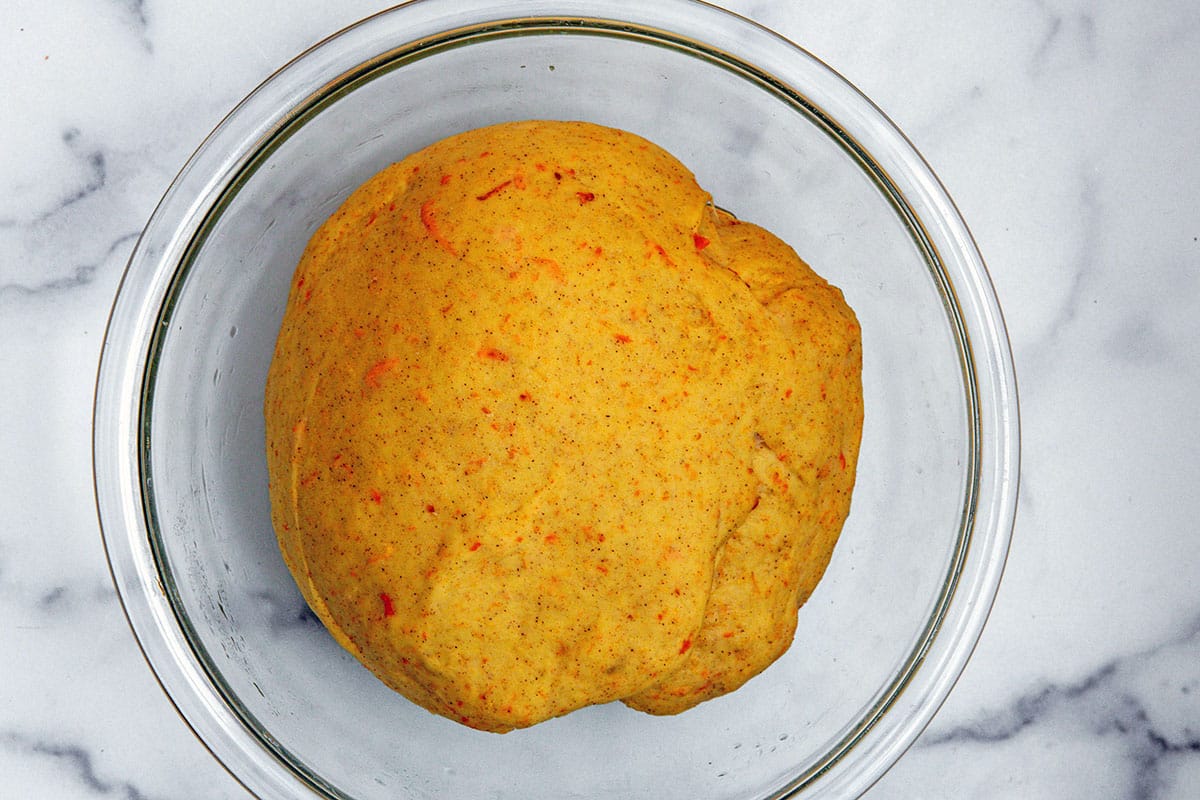 Carrot cake cinnamon roll dough risen in mixing bowl.