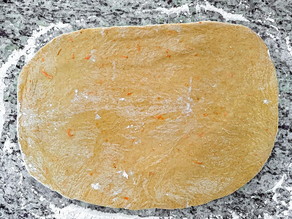 Cinnamon roll dough rolled into a rectangle.