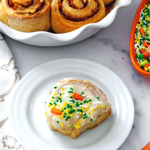 Closeup view of a carrot cake cinnamon roll with cream cheese frosting.