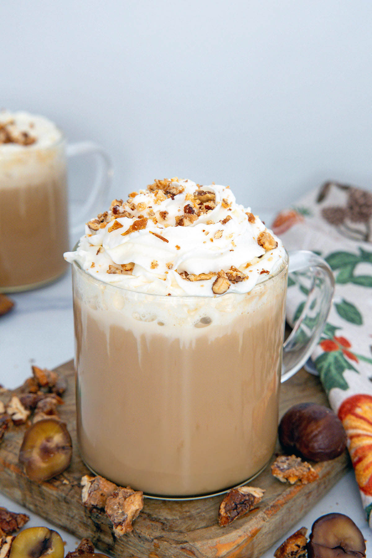 Chestnut Praline Latte with whopped cream and crumble topping with chestnut and praline pieces all around.