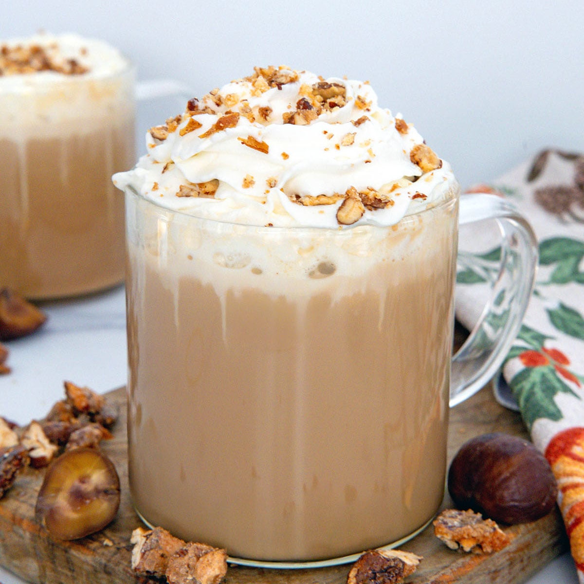 Closeup view of a Chestnut Praline Latte with whipped cream and praline crumble.