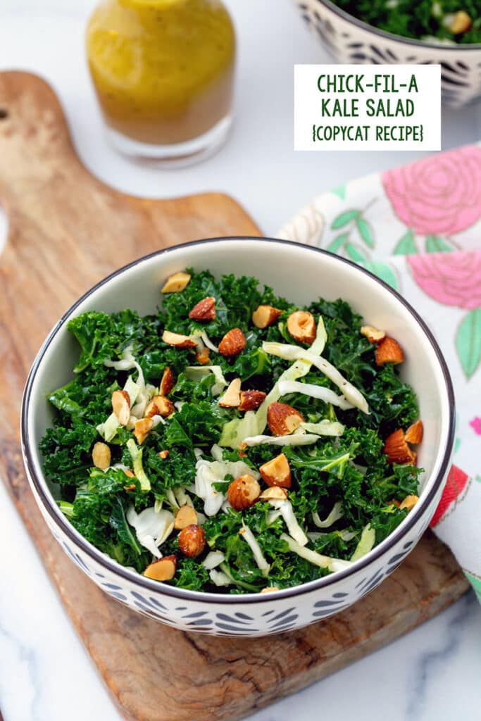 Overhead view of a kale salad with green cabbage and almonds with small bottle of dressing in background and recipe title at top.