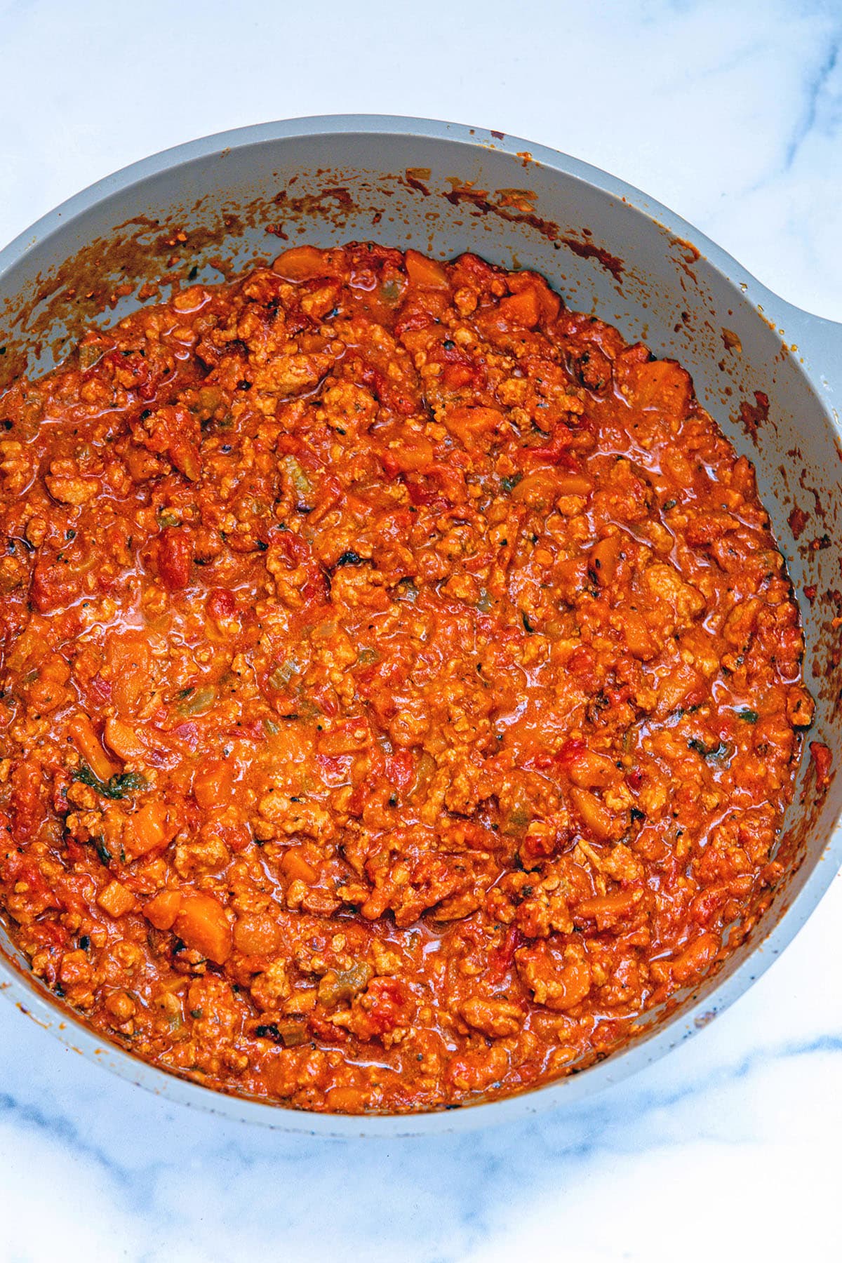 Bolognese sauce cooking in skillet.