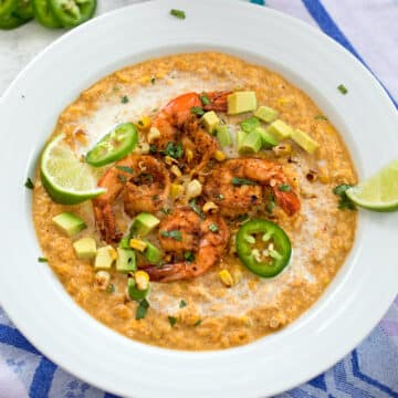 Overhead closeup view of a bowl of chilled corn bisque topped with shrimp and jalapeño.