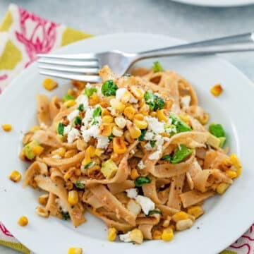 Closeup view of a plate of chipotle corn fettuccine topped with feta cheese.