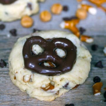 Closeup view of a cookie with chocolate covered pretzel on it.