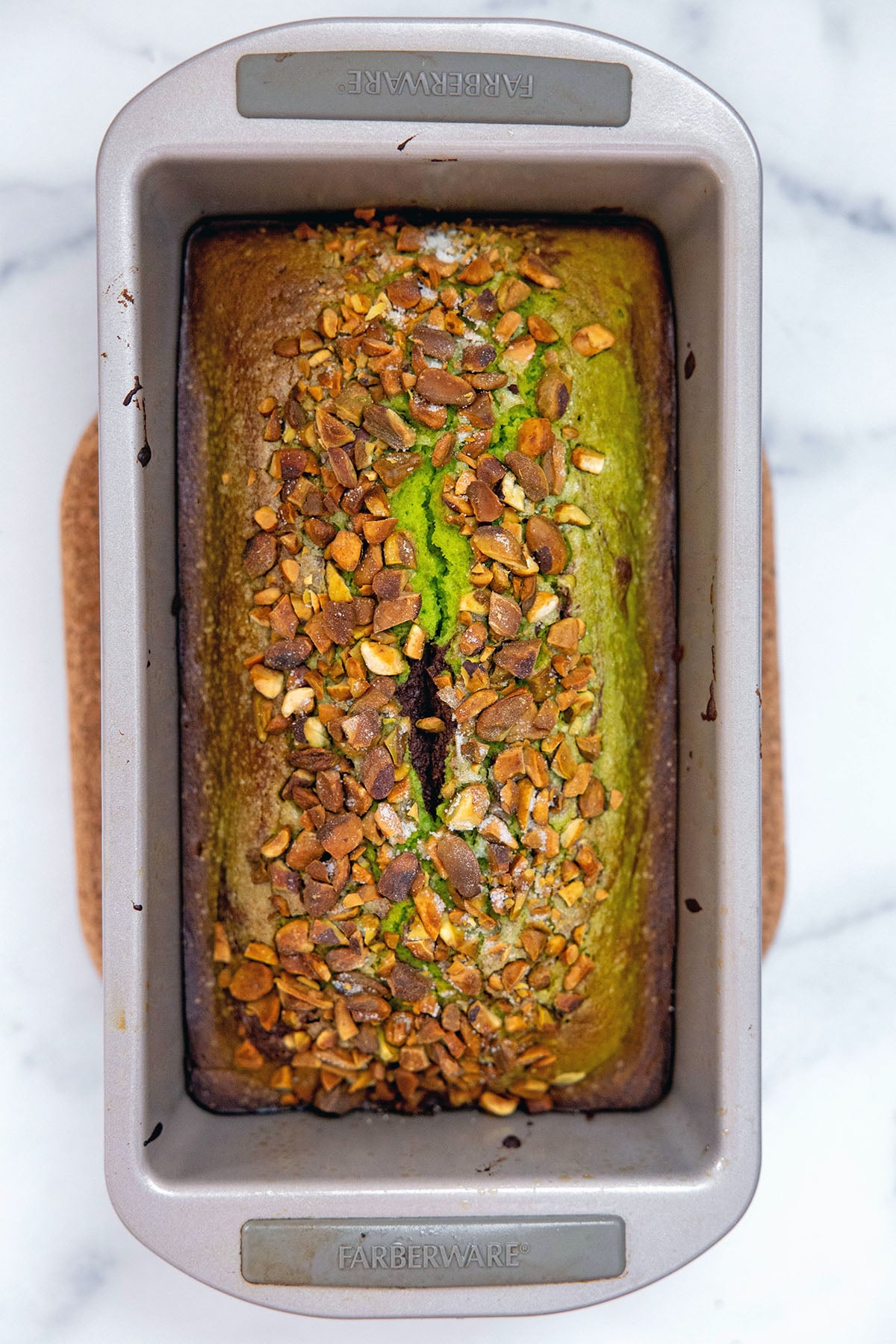 Baked chocolate pistachio loaf topped with pistachios.