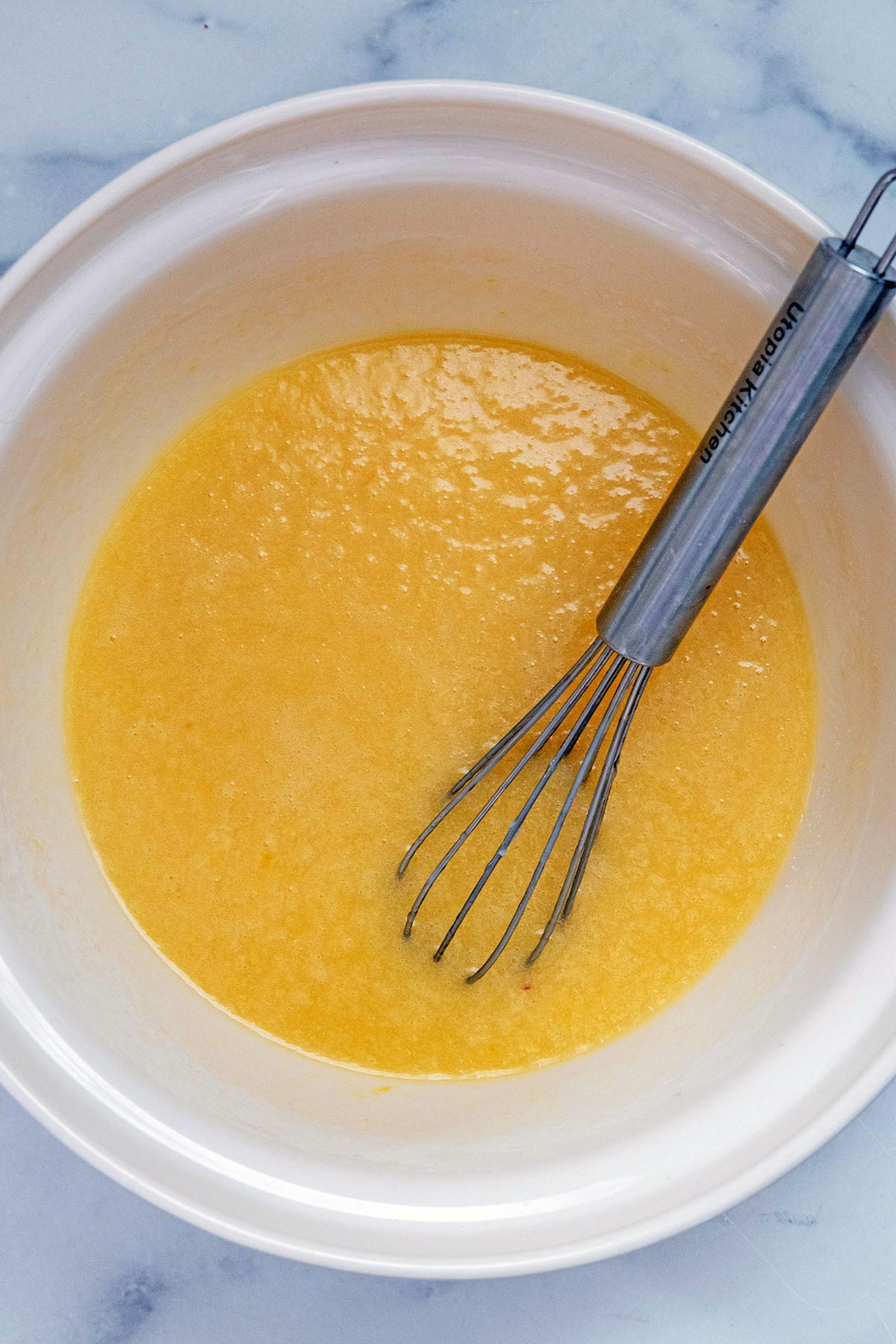 Eggs, buttermilk, butter, and oil in mixing bowl with whisk.