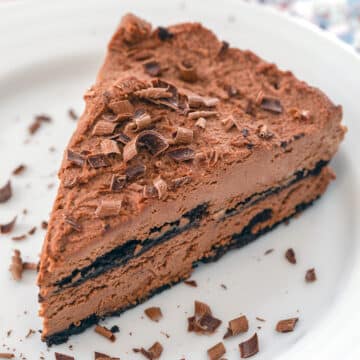 Closeup view of a slice of chocolate ricotta cake with chocolate shavings.