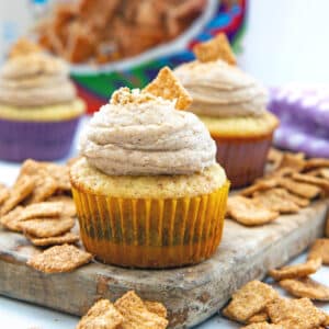 Head-on closeup view of a Cinnamon Toast Crunch cupcakes with cereal all around.