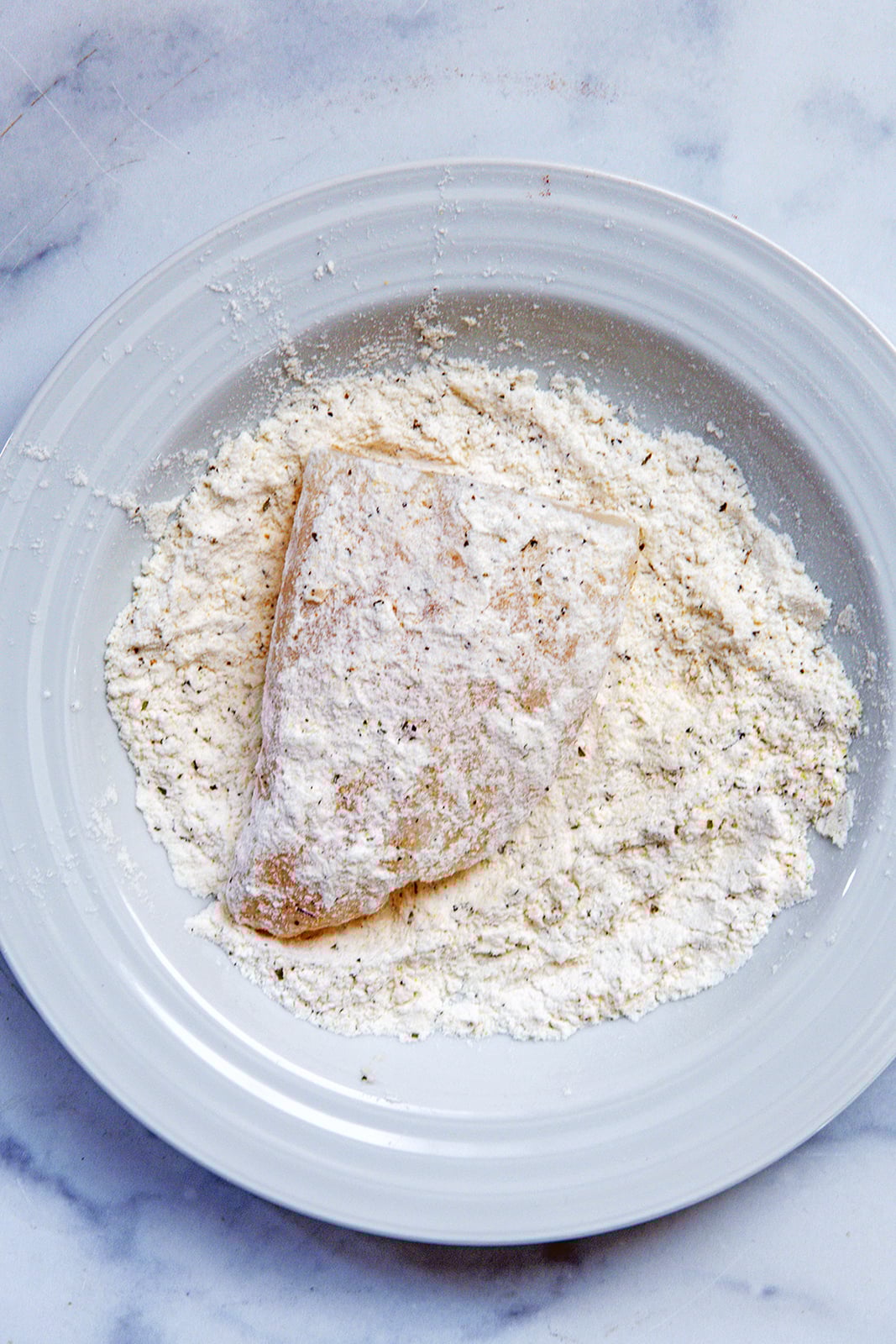 Cod filets being dredged in flour.