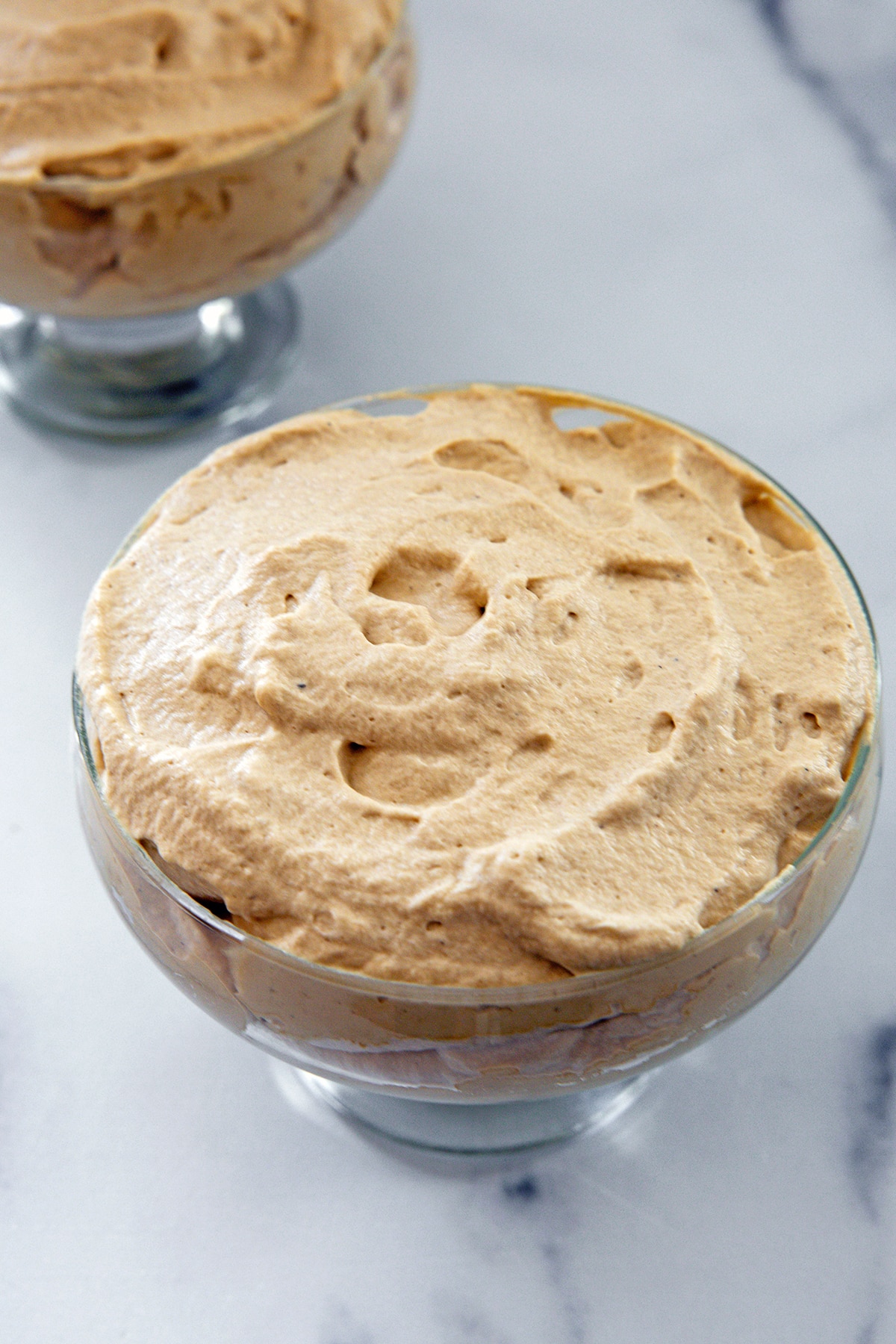 Coffee mousse scooped into glass ramekin.
