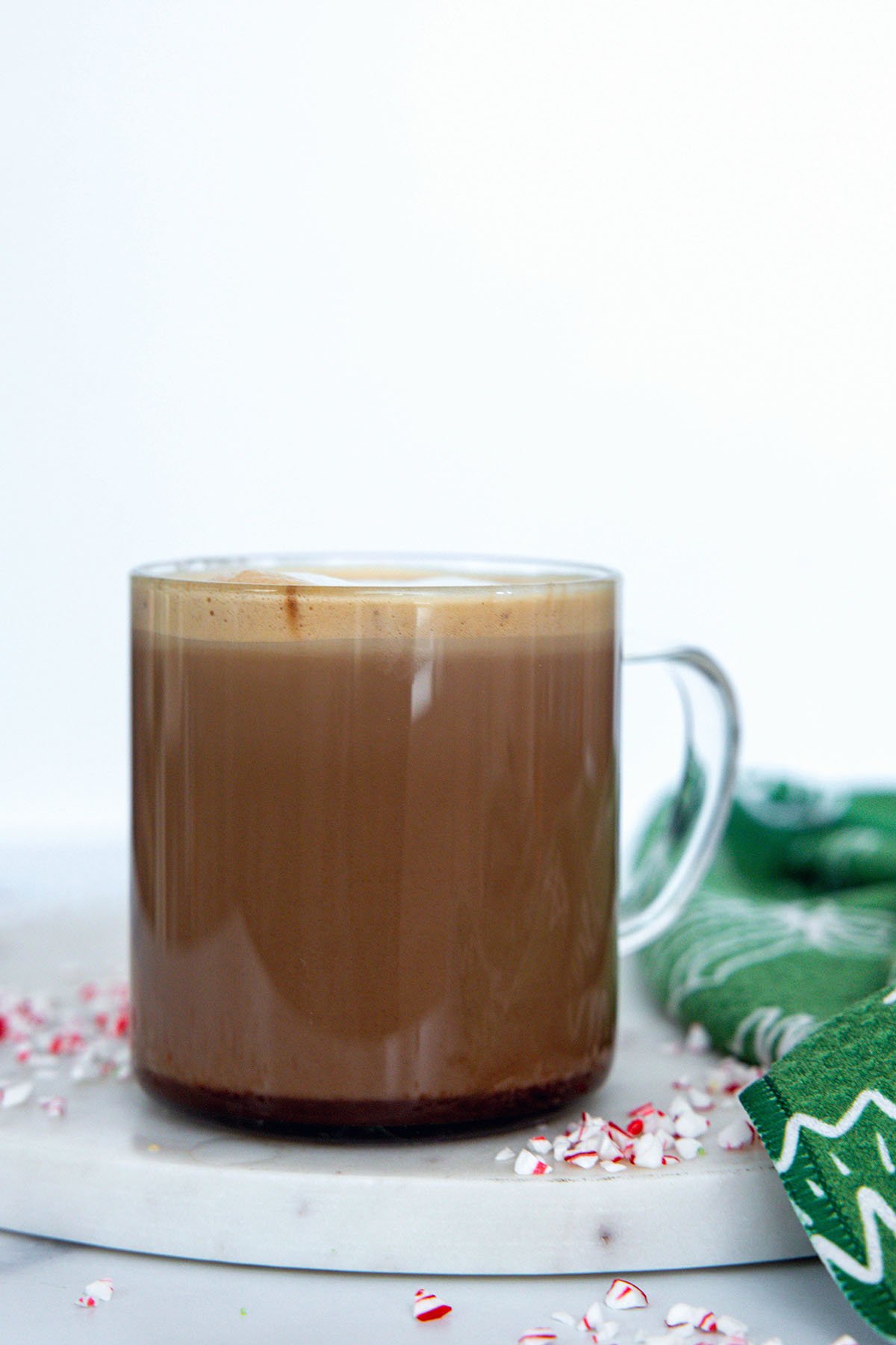 Head-on view of a clear mug filled with peppermint mocha.