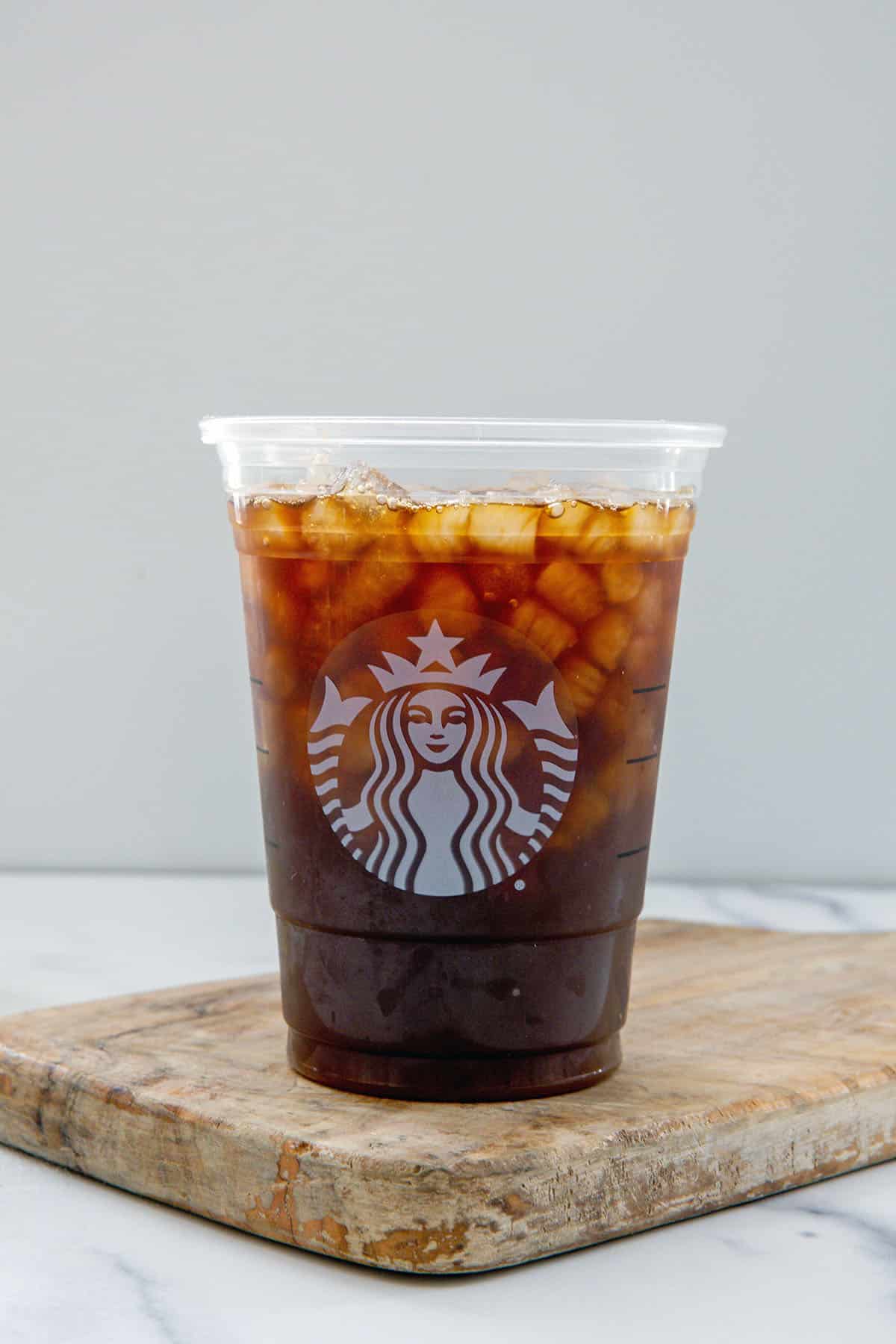 Cold brew in cup with hazelnut syrup and ice.