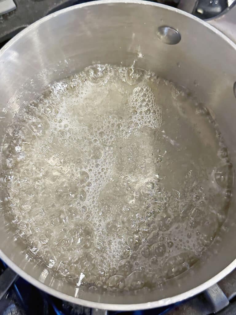 Corn syrup, sugar, and water simmering in saucepan.