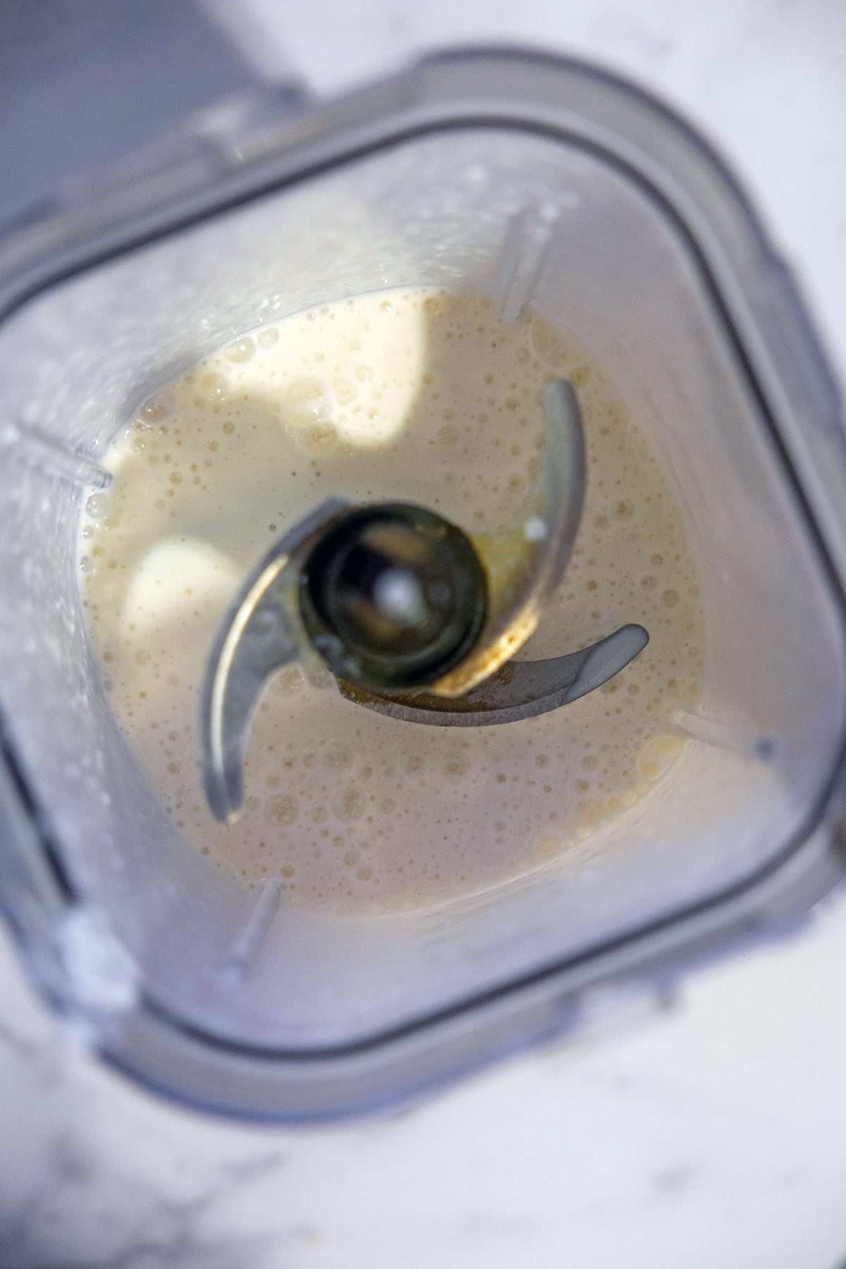Overhead view of cottage cheese, yogurt, milk mixture in blender.