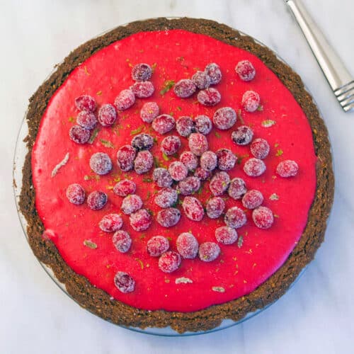 Close-up overhead view of a cranberry lime pie with sugared cranberries on top.