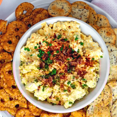 Closeup view of deviled egg dip with paprika and chives.