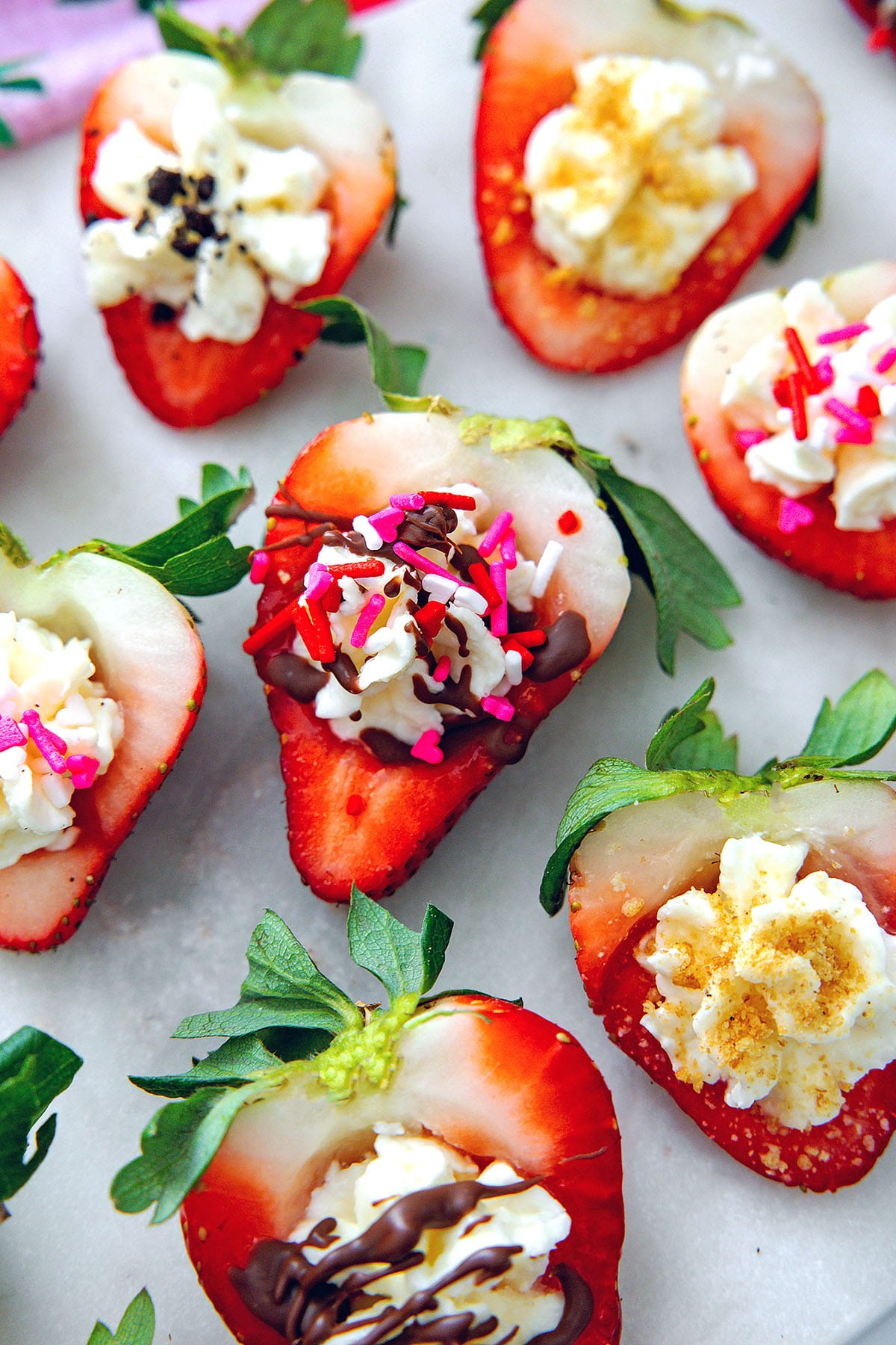 Overhead view of deviled strawberries with chocolate, sprinkles, and graham cracker crumbs.