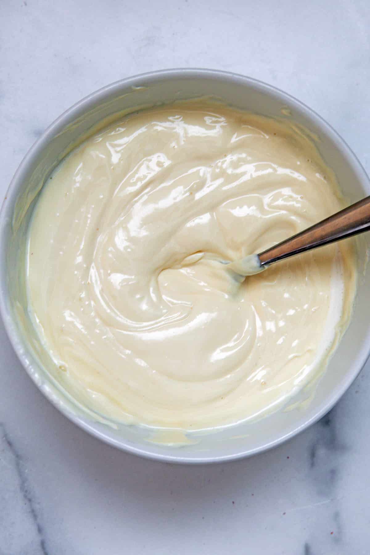Vanilla icing mixed in bowl.