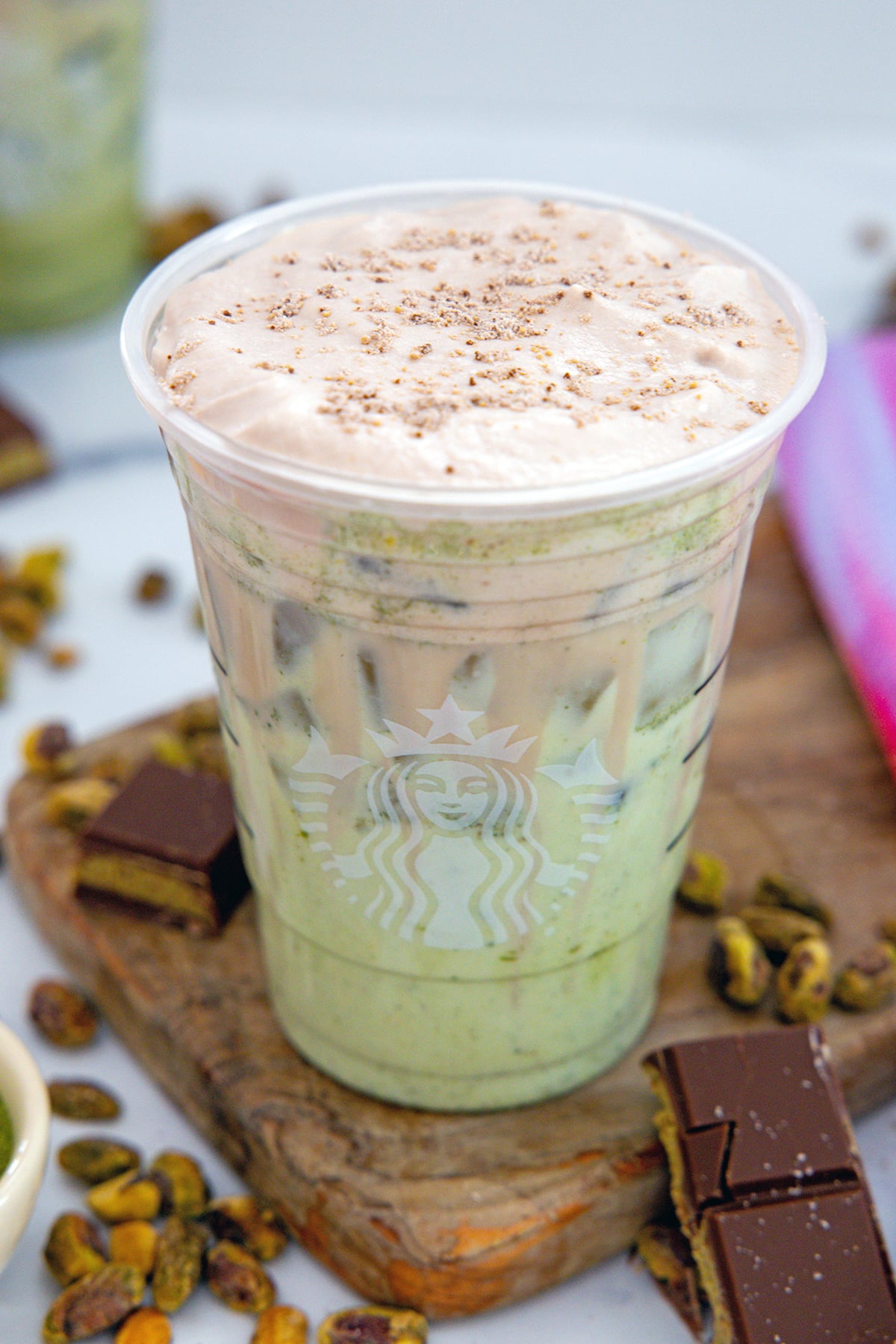 Overhead view of a Starbucks Iced Dubai Chocolate Mocha showing chocolate coal foam and brown butter topping.