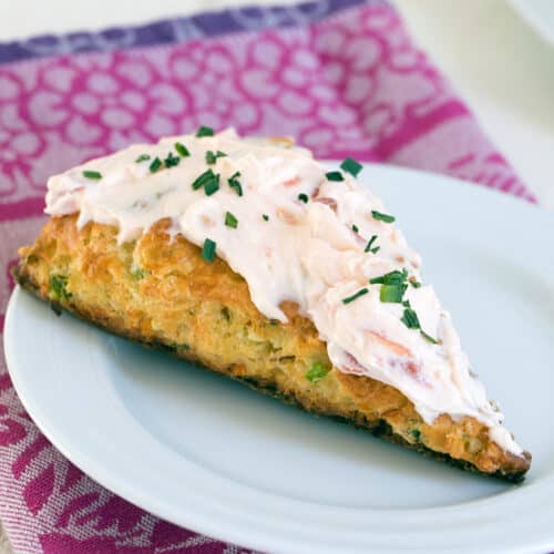 Closeup view of a vegetable scone with tomato cream cheese frosting.