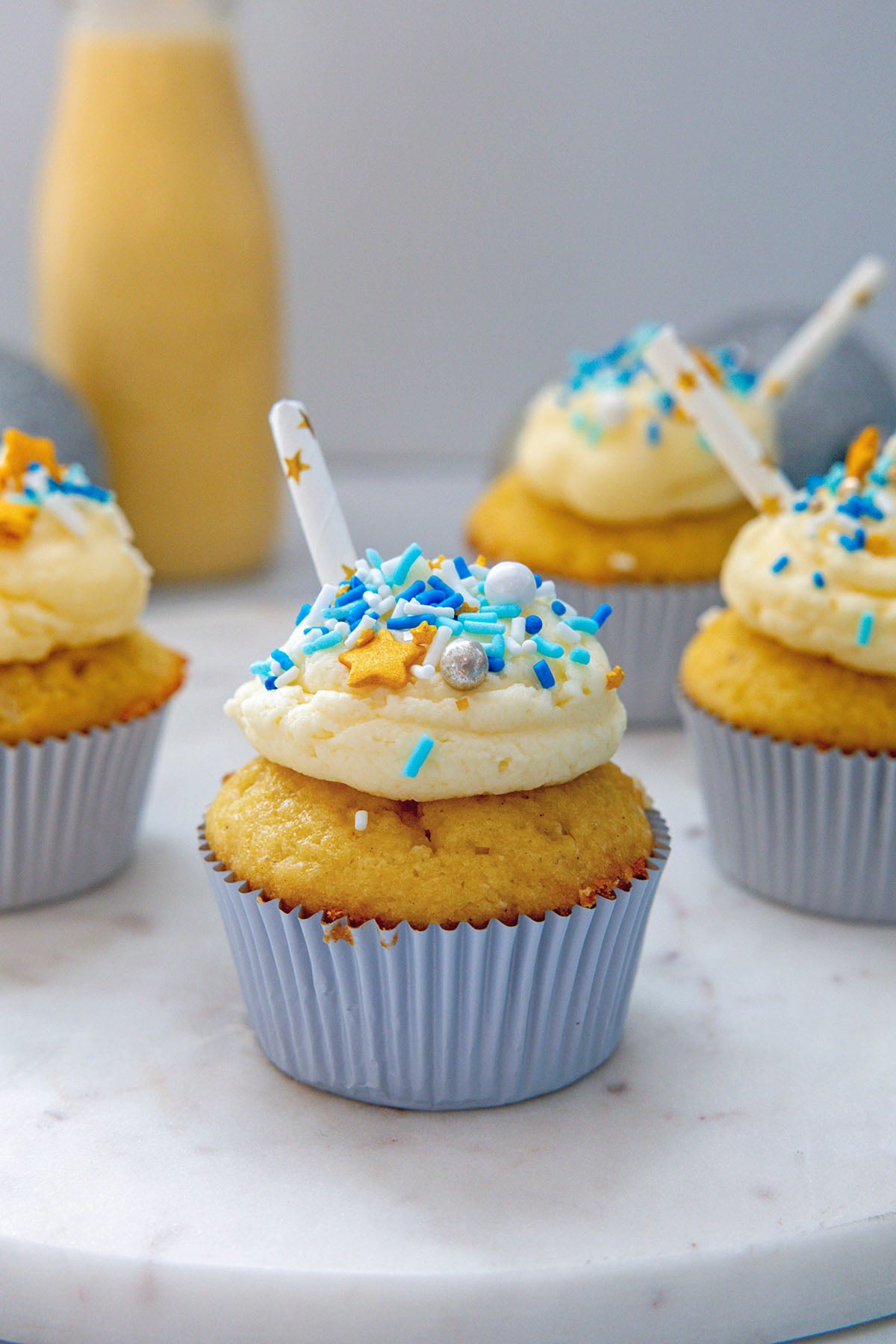 Head-on view of an eggnog cupcake with more cupcakes in background.