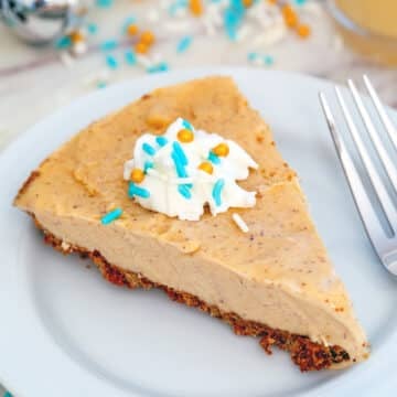 Overhead closeup view of a slice of eggnog ice cream pie with whipped cream and sprinkles.