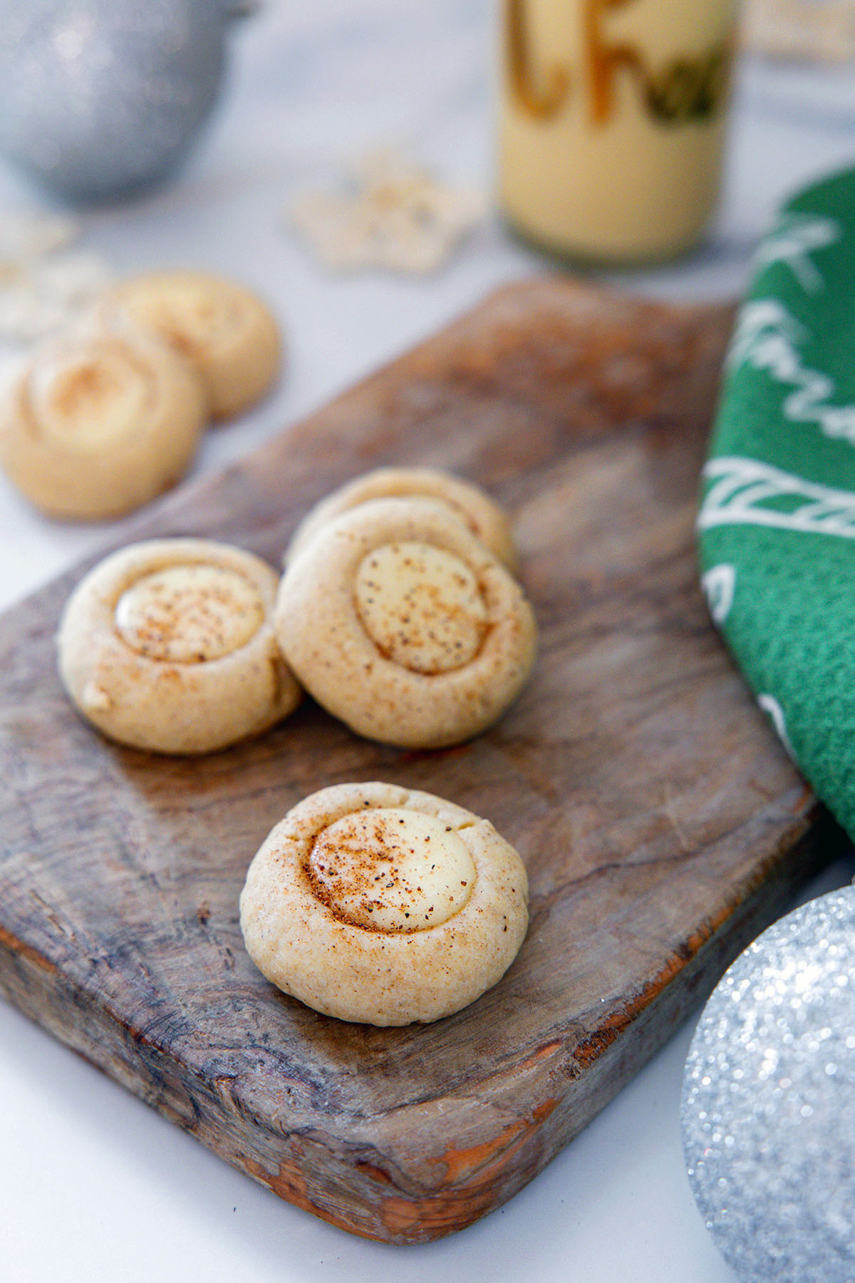 Overhead view of eggnog thumbprint cookies with jar of eggnog.