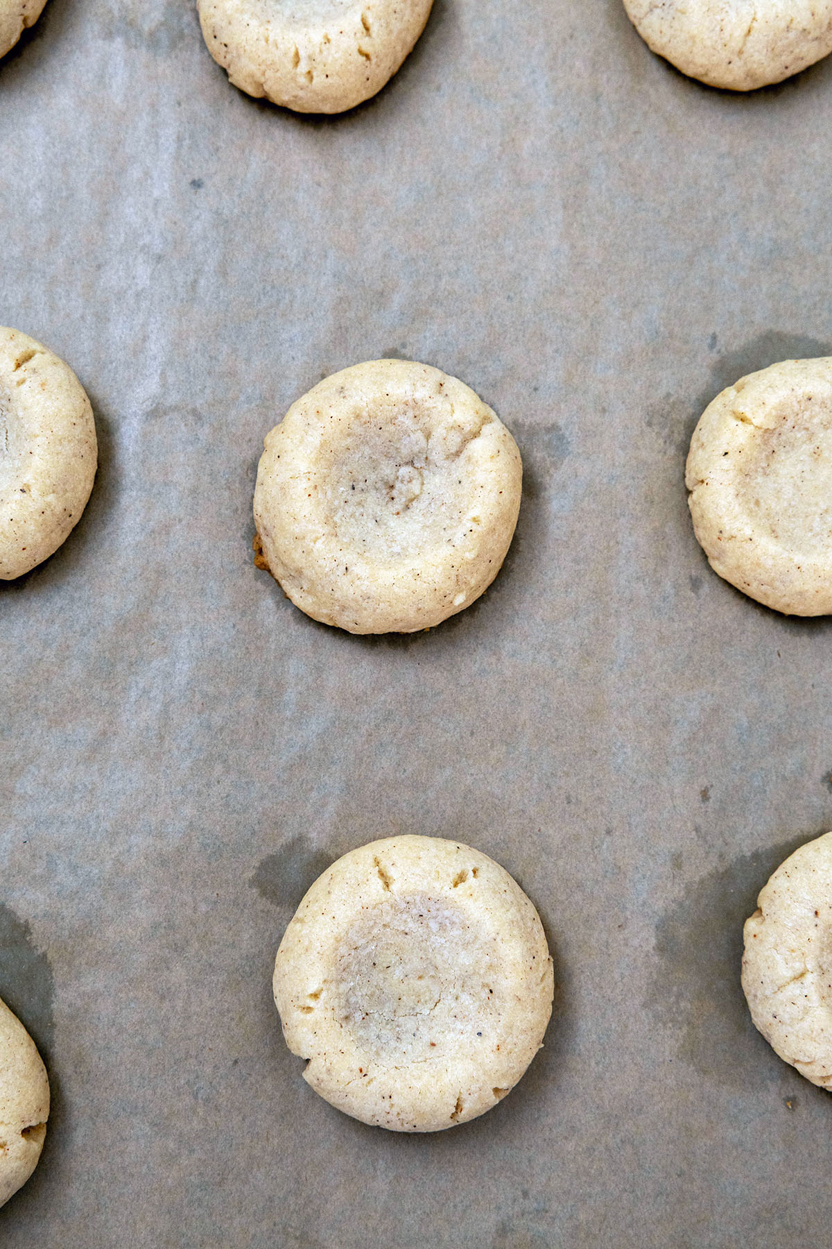 Eggnog thumbprint cookies baked on baking sheet.