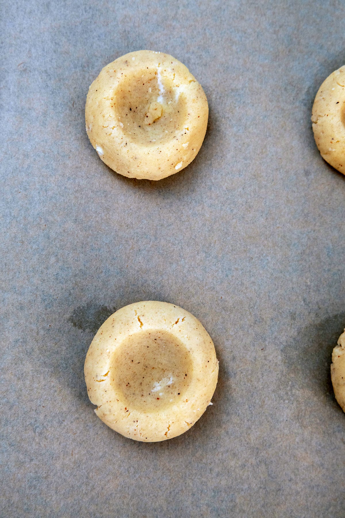 Eggnog cookie dough formed into thumbprint cookies.