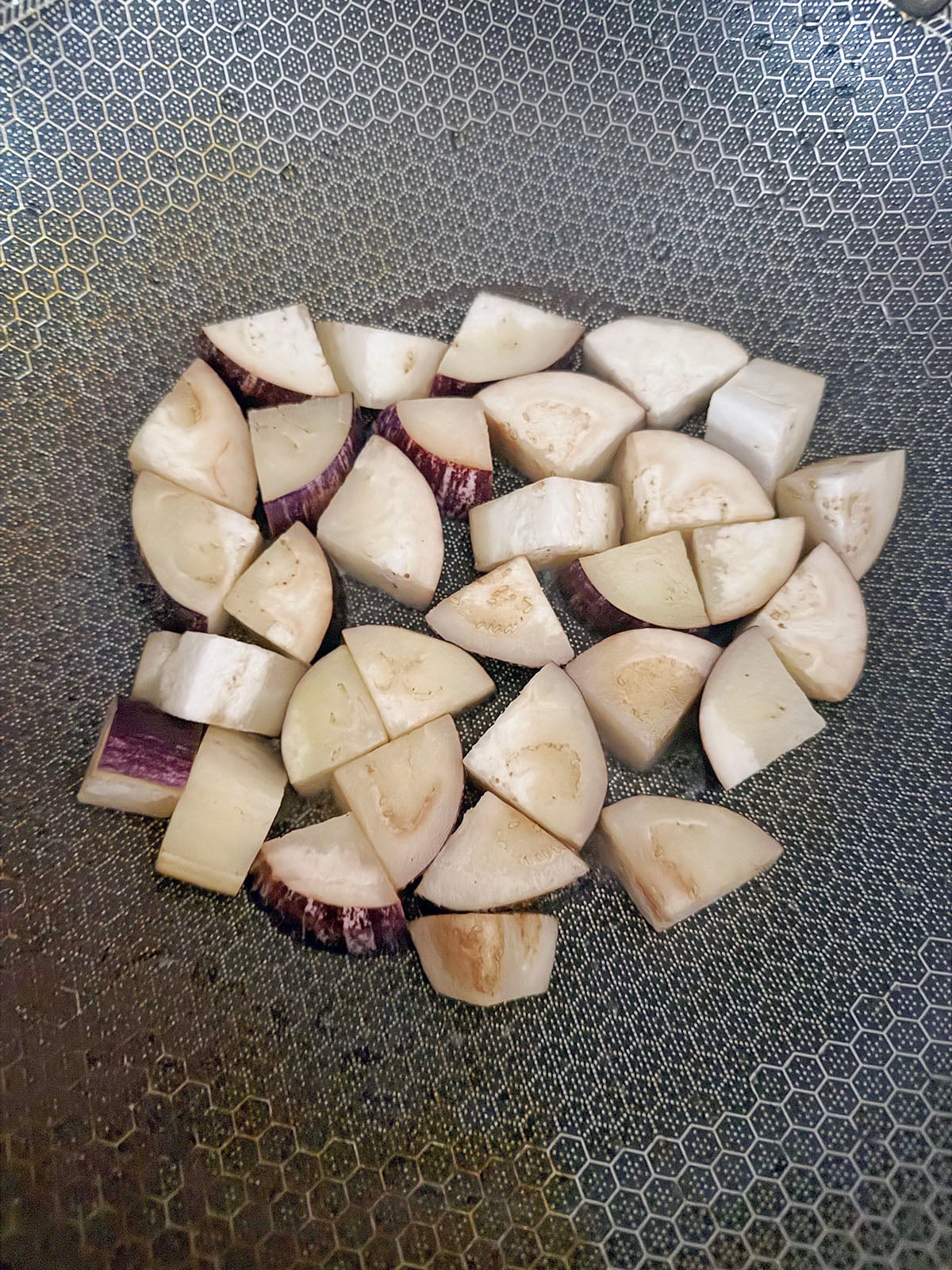 Eggplant chunks in wok.