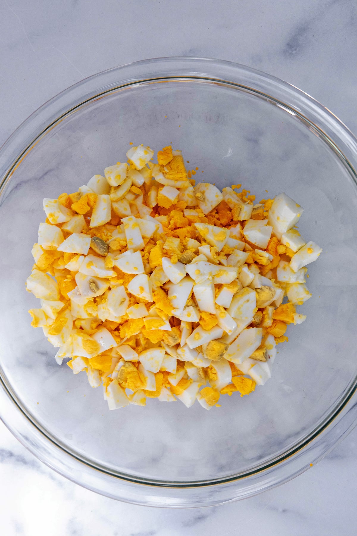 Hardboiled eggs chopped in bowl.