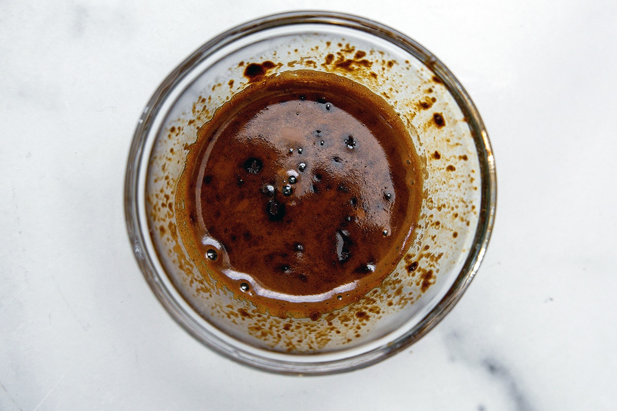 Espresso and water mixed together in a small bowl.