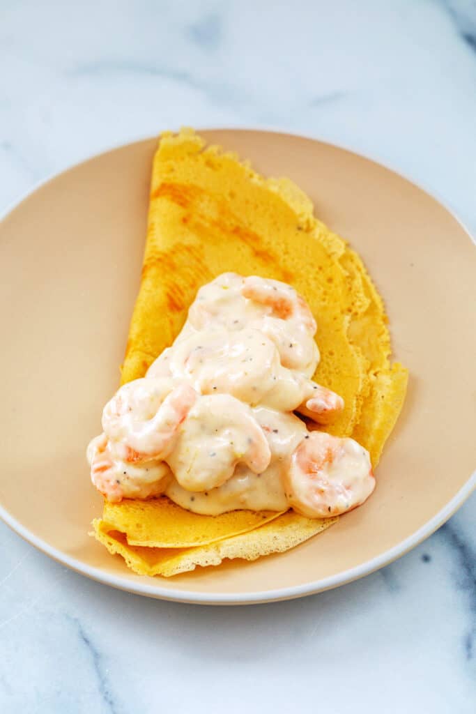 Crepe folded over and topped with creamy shrimp.
